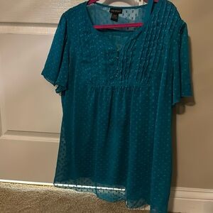 Teal blouse with camisole under sheer fabric.